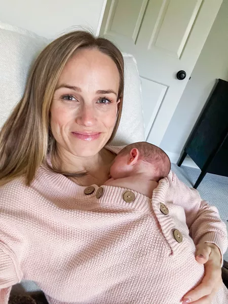 Woman holding baby skin on skin while wearing Amazon Midi Button Front Sweater Dress