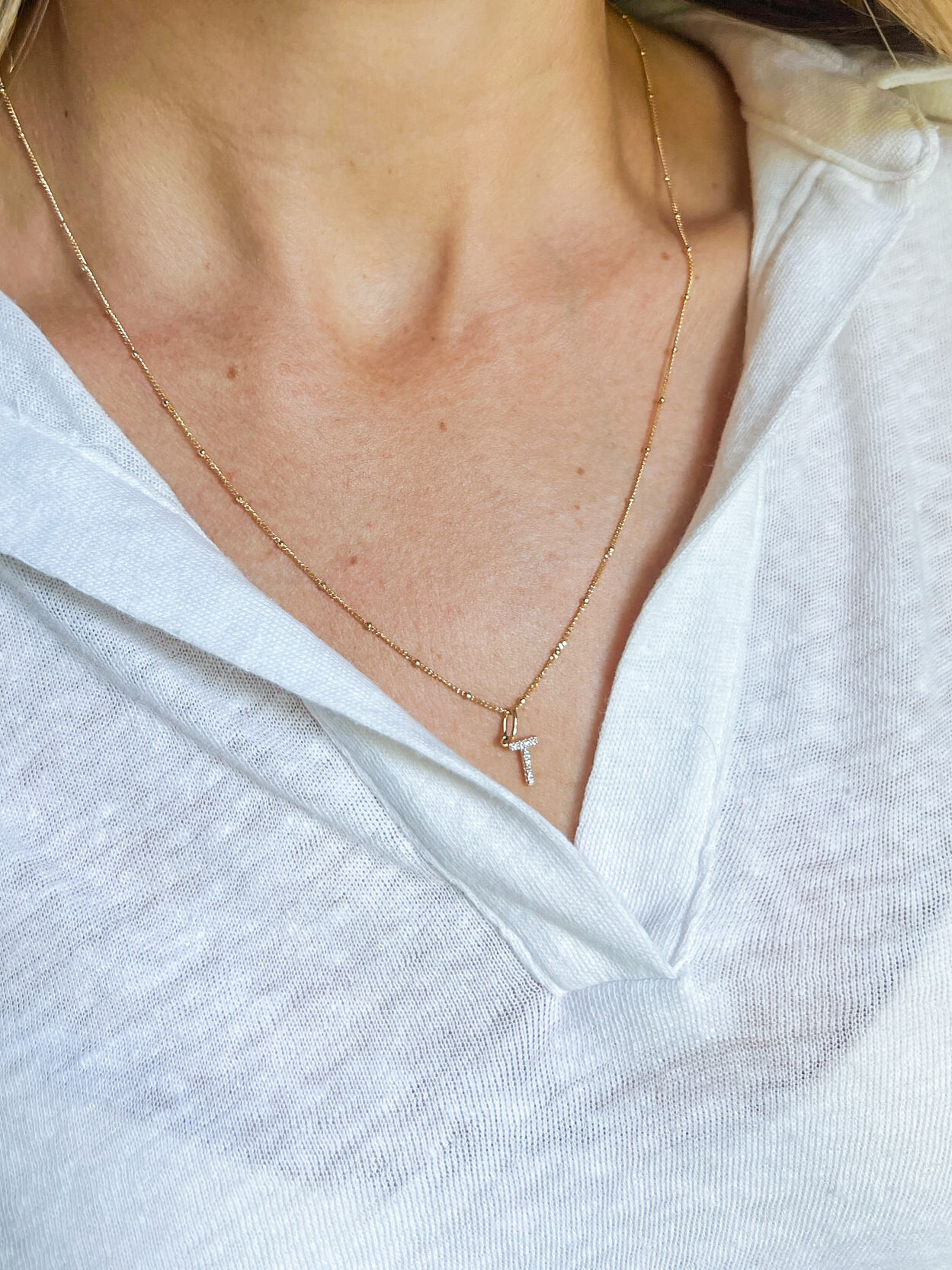 Woman wearing Mejuri Diamond Letter Charm 