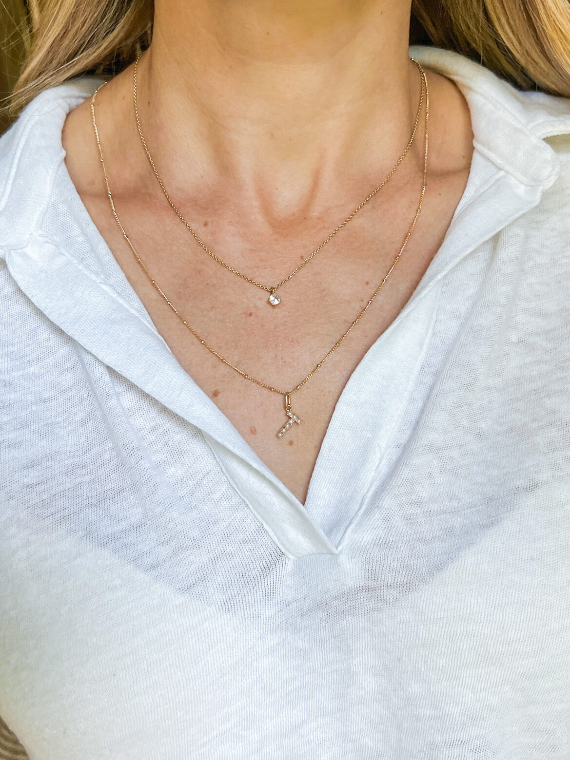 Woman wearing Mejuri Pearl Letter Charm Necklace with Mejuri Spheres Chain