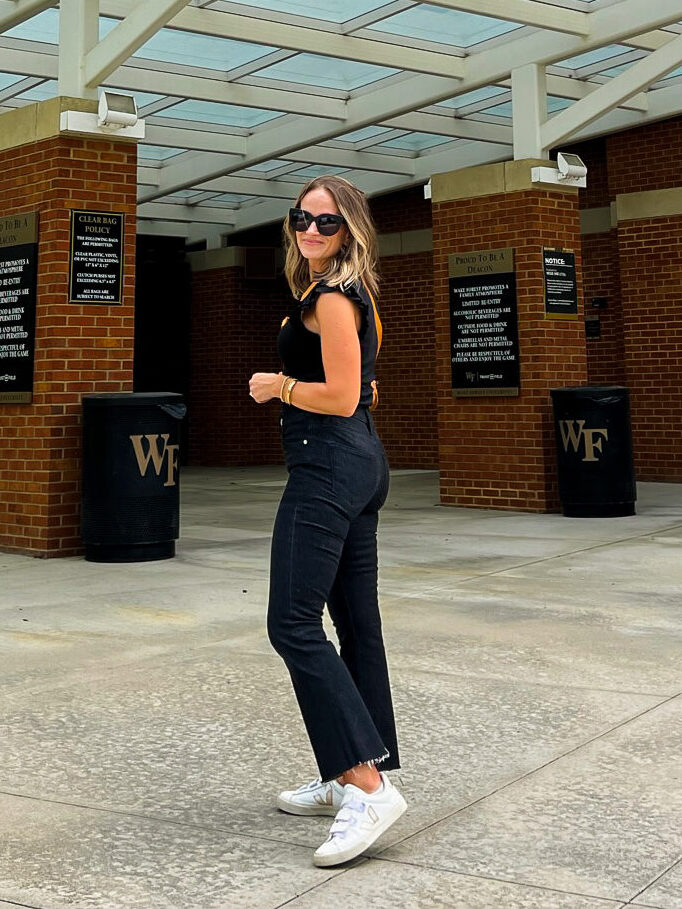 woman wearing black top and black jeans with white sneakers