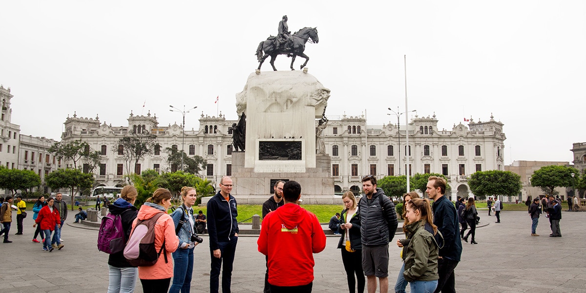 grupo de turistas en el centro de lima escuchando a su guía - tours en Lima