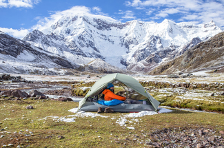 Ausangate Trek Peru - Person in tent with ausangate mountains in background