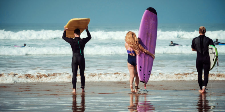Des surfeurs qui entre à l'eau sur le spot de surf de Mancora.