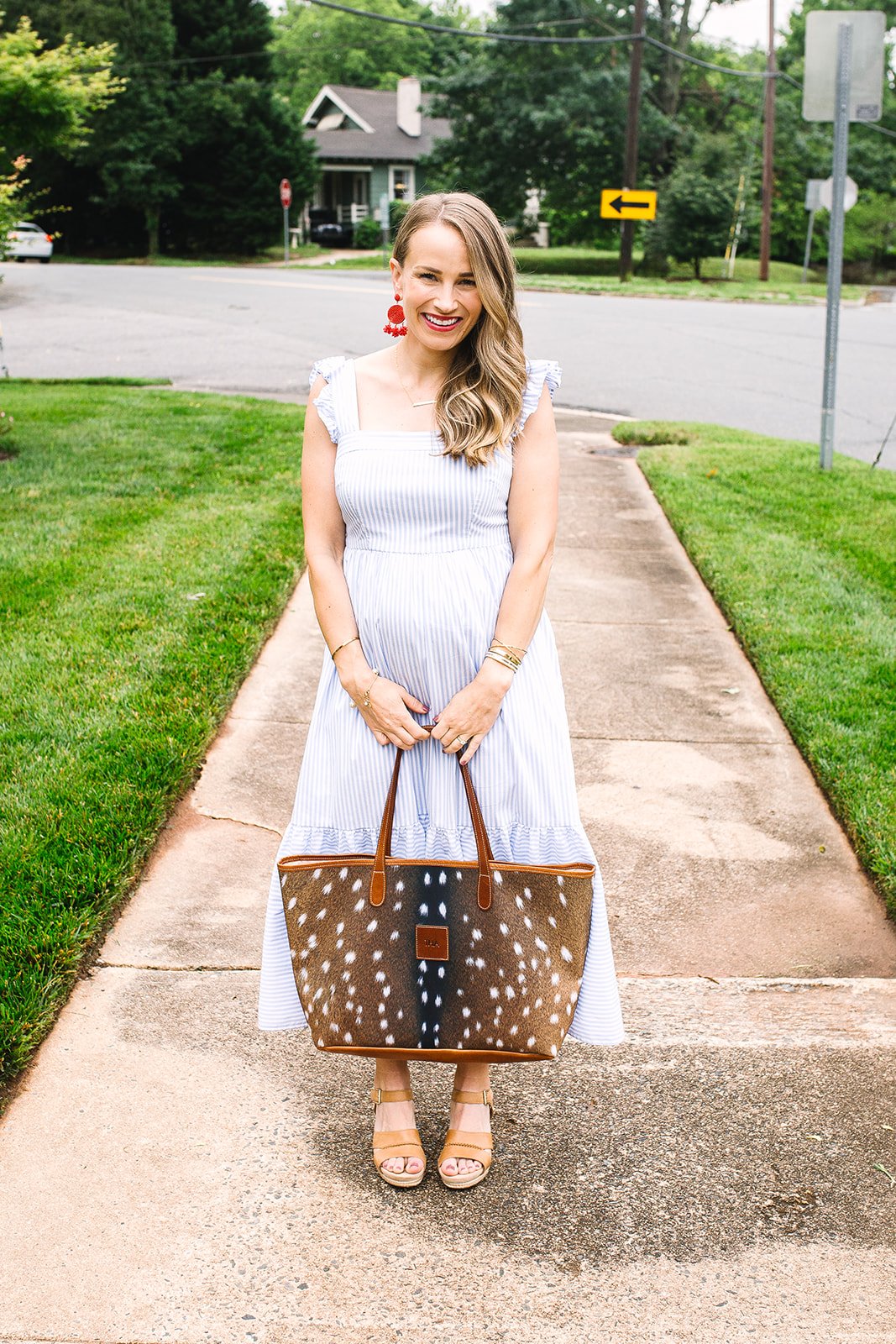 TeriLyn Adams wearing striped dress and holding a bag