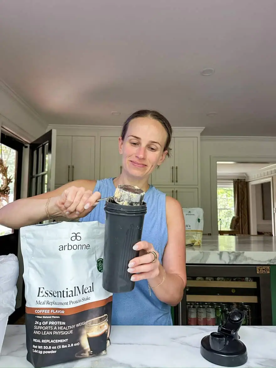 Woman making Arbonne EssentialMeal Meal Replacement Protein Shake