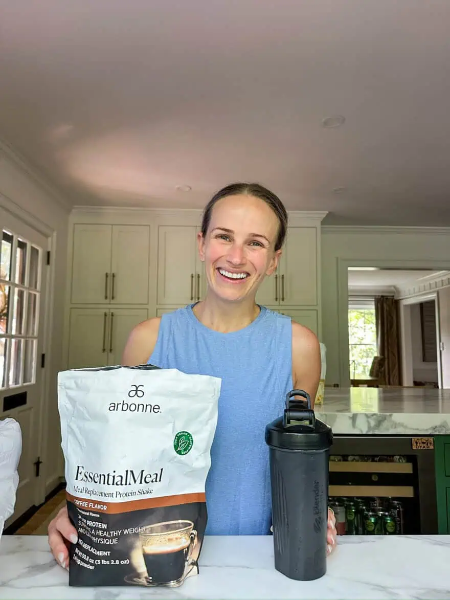 Woman holding Arbonne EssentialMeal Meal Replacement Protein Shake